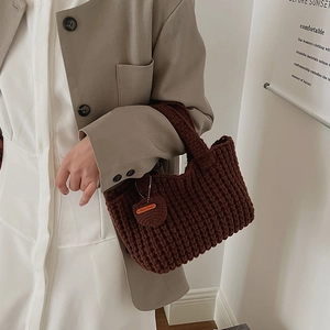 Détail du sac à main en crochet marron foncé avec charm cœur et étiquette Hand Made