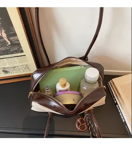 Detail view of spacious canvas and leather shoulder bag interior holding personal items