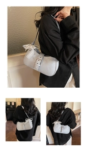 Vue détaillée du sac bleu clair avec nœud en dentelle blanche et pendentif en perle