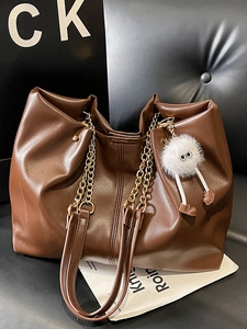 Vintage brown leather tote bag with stylish chain strap and cute plush toy pendant