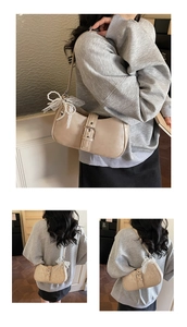 Détail d'un sac bandoulière beige en demi-lune avec gland en perles et nœud au manche