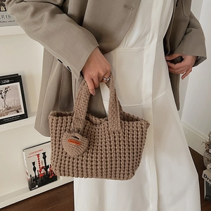 Détail du sac à main au crochet kaki foncé avec texture gaufrée et breloque en cœur