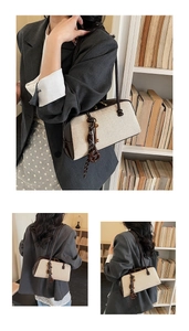Detail shots of canvas underarm bag with leather trim and keychain on a model