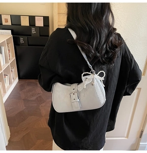Détail du sac sous le bras bleu élégant avec un nœud en dentelle et des perles
