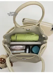 Internal view of beige bucket bag showing large capacity for umbrella and cosmetics