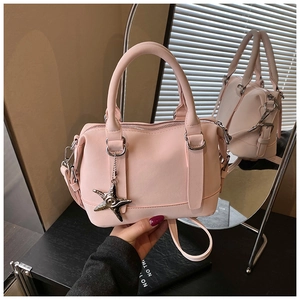 Close-up of pink PU leather Boston bag with star charm and detachable shoulder strap