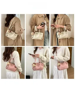 Detail showing litchi grain leather bucket bag with cute bear charm and thin strap