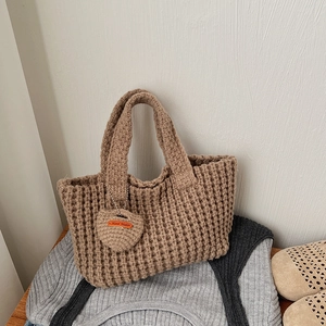 Détail de la texture gaufrée du sac fourre-tout en crochet kaki avec pendentif en cœur