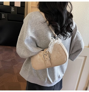 Vue détaillée du sac sous le bras beige avec nœuds en dentelle, perles et boucle vintage