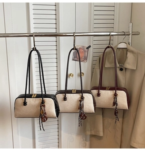 Detailed macro view of retro canvas and leather shoulder bags in black, brown and burgundy