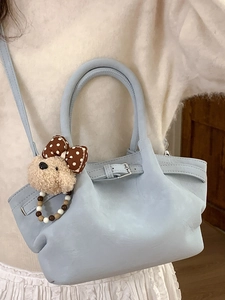 Chic light blue pleated bucket bag with plush bear charm and crossbody strap