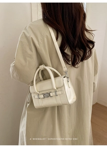 Borsa bianco crema con trama a coccodrillo su modella con dettagli retrò minimalisti