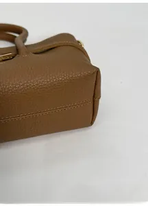 Detailed macro view of the wide-bottomed leather handbag showing premium stitching details