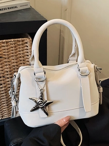 White PU leather Boston bag with star charm and shoulder strap in a cozy home setting