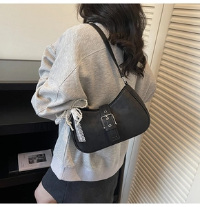Détail du sac croissant noir avec breloque en dentelle et perle et boucle argentée