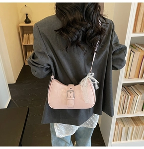 Sac hobo rose en demi-lune avec nœud en dentelle blanche sur une veste de blazer