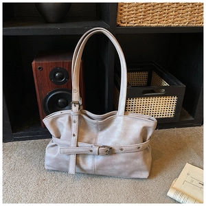 Detailed macro view of gray PU leather tote bag with decorative straps and metal eyelets