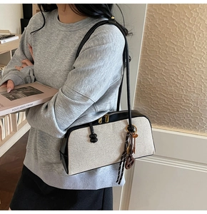 Close-up detail of the canvas and black leather trim contrast on a large shoulder bag