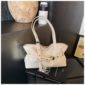Detailed view of the off-white gathered pleats and decorative metal buckle strap on the bag