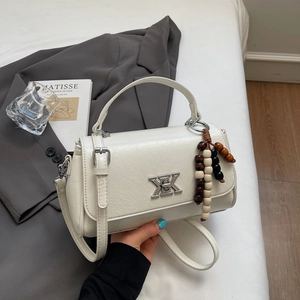 Détail du sac en cuir plissé blanc avec pendentif en perles de bois et boucle en métal