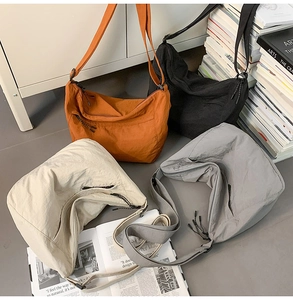Macro shot of large nylon tote bags in four colors with adjustable shoulder straps