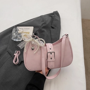 Détail du sac hobo rose avec boucle argentée et breloque en dentelle de perles