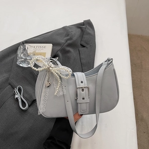 Détail du sac hobo avec boucle argentée et pendentif en dentelle de perles