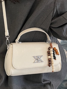 Petit sac carré beige élégant avec fermoir argenté en X et décoration de perles en bois