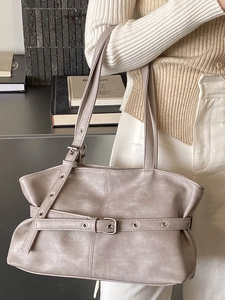 Minimalist taupe underarm tote bag with metal eyelets and decorative buckle strap detail