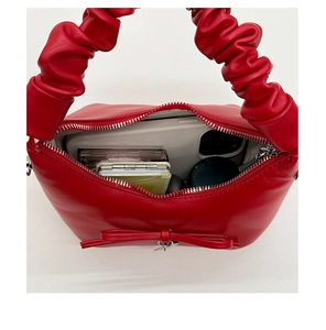 Top view of red bucket bag showing interior space with phone and makeup essentials