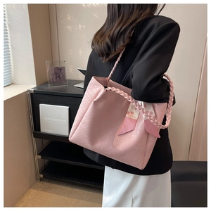 Pink tote bag with star embossing, woven handles and decorative scarf on side