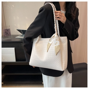 Detailed close-up of cream tote bag featuring houndstooth texture and woven rope handle