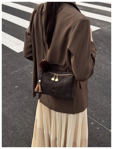 Detailansicht braune Vintage-Kissentasche mit goldenen Reißverschlüssen und Lederquaste
