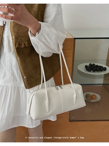 Dettaglio dell'elegante borsa a tracolla bianca vintage con doppie tracolle e zip metalliche