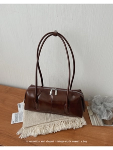 Dettaglio borsa a cilindro vintage marrone scuro con doppi spallacci sottili lucidi
