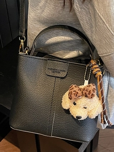 Elegante borsa a secchiello in pelle nera con manico e ciondolo a forma di cane di peluche