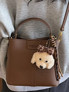 Borsa a secchiello marrone grana litchi con ciondolo a cane e sciarpa a righe