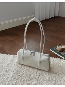 Dettaglio borsa a spalla vintage in pelle bianca con doppia cerniera su tappeto
