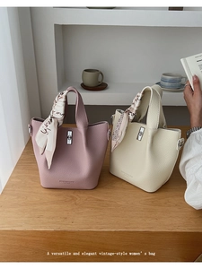 Detail of leather bucket bags in pink and white with printed silk scarves on handles
