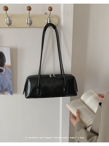 Vista dettagliata di una borsa a tracolla nera vintage con spalline sottili e zip in metallo