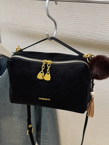 Minimalistische schwarze Kissentasche für Damen mit goldenem Reißverschluss und Plüschball