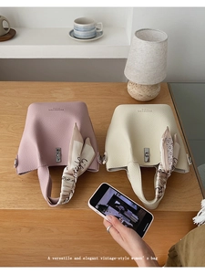 Detail of vintage bucket bags in pink and beige leather with printed silk scarves