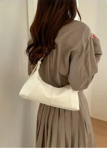 Detail of off-white lychee grain leather shoulder bag with fine stitching and silver hardware