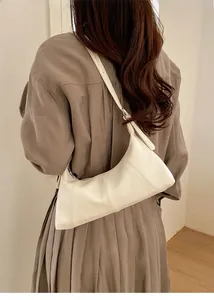 Close-up of a white hobo bag with litchi texture leather and elegant vertical stitching