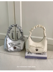 Detail of silver and beige crescent bucket bags with bow decor and heart charms
