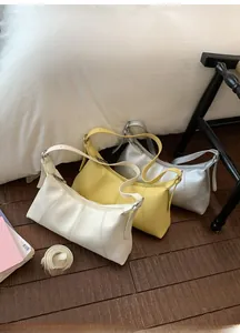 Detailed close-up of three lychee texture leather dumplings bags in white, yellow, and silver
