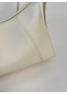Close-up of premium creamy white pebbled leather material with durable double stitching detail