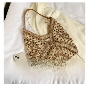 Detail view of large crochet beach tote bag with leather strap next to mobile for scale