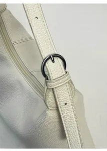 Detail view of adjustable leather strap with silver ring buckle on white dumpling bag