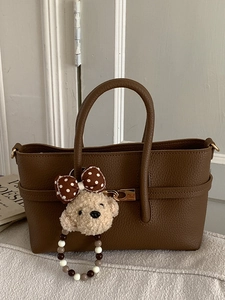 Classic dark brown leather tote bag with gold hardware and a cute plush bear charm